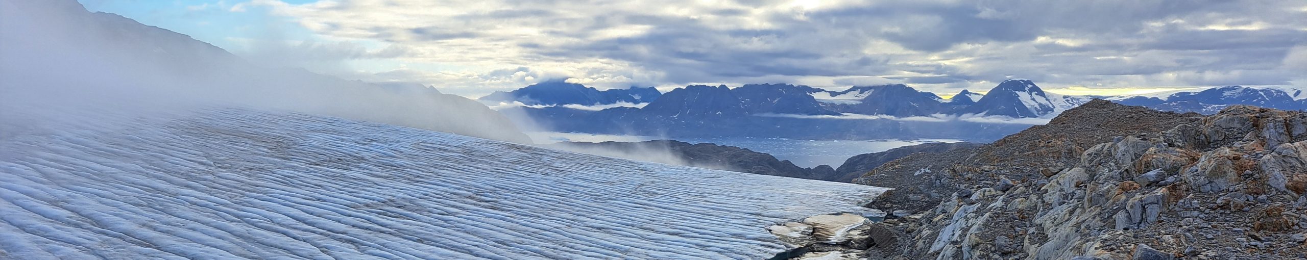 glacier with fjord and mountains in the background