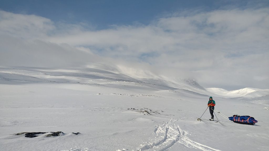 Snowy landscape with a person towing a pull